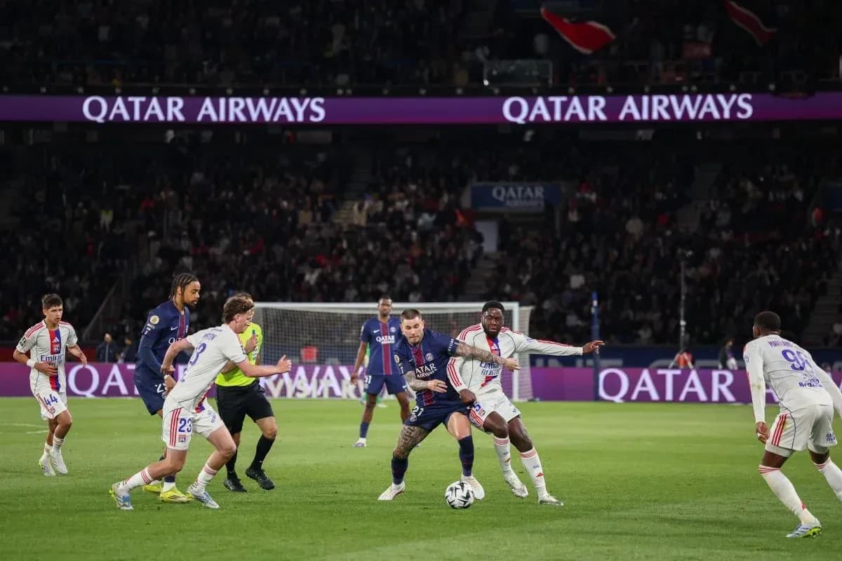 Игроки PSG и Lyon борются за мяч на поле