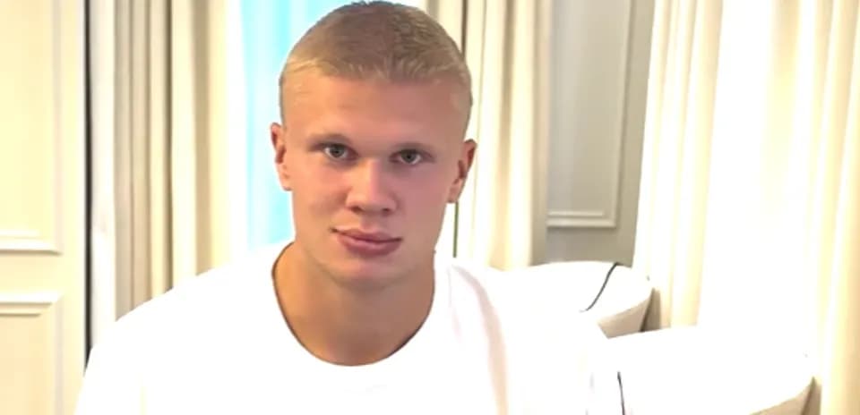 Игрок в белой футболке сидит на диване
