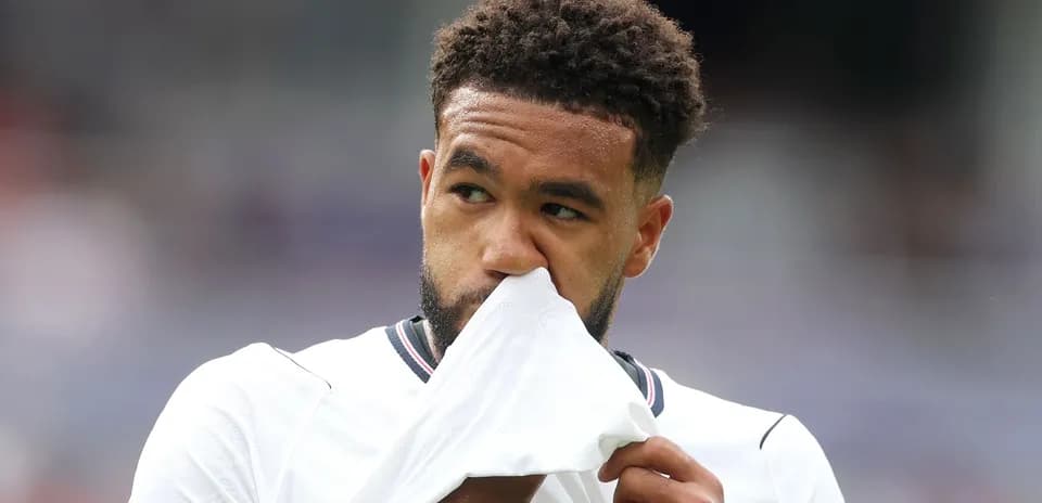 Игрок держит футболку перед лицом на поле