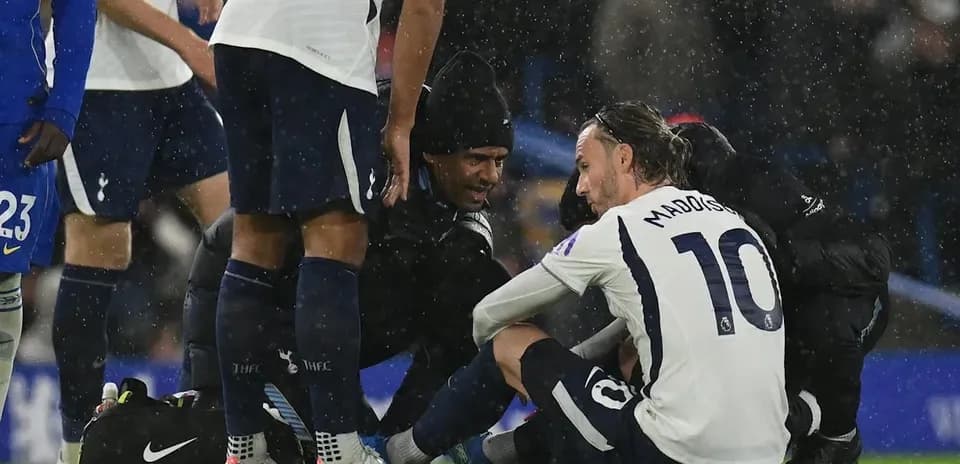Игрок Tottenham на земле с медицинским персоналом