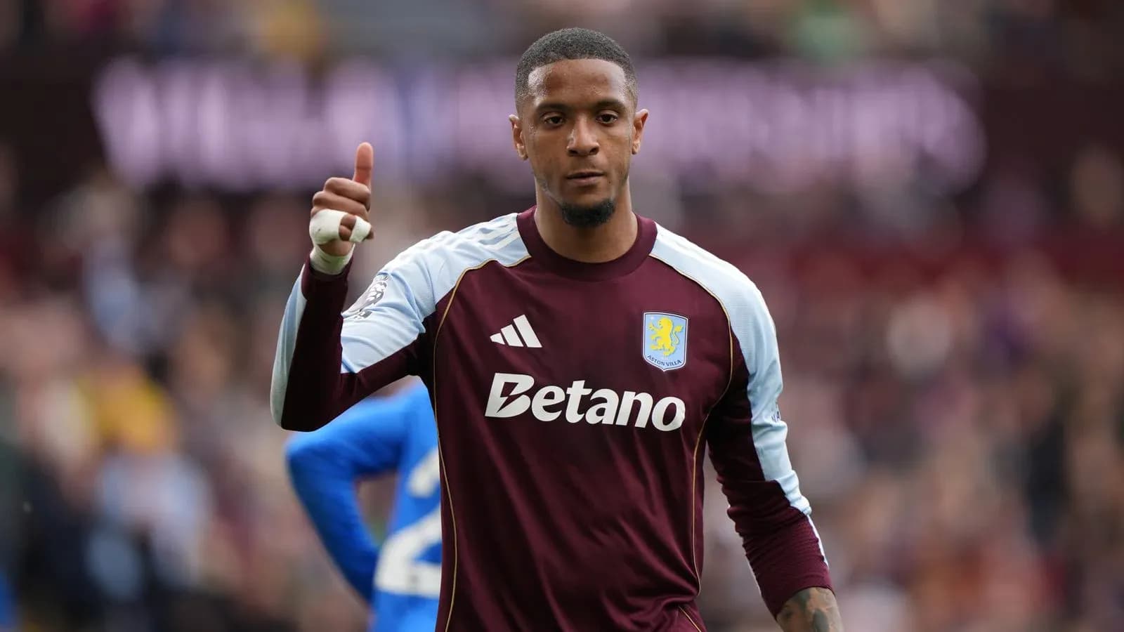 Вратарь Aston Villa показывает жест одобрения на поле