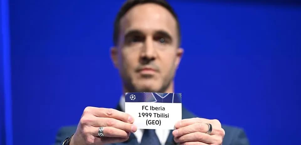 Человек держит карточку FC Iberia 1999 Тбилиси