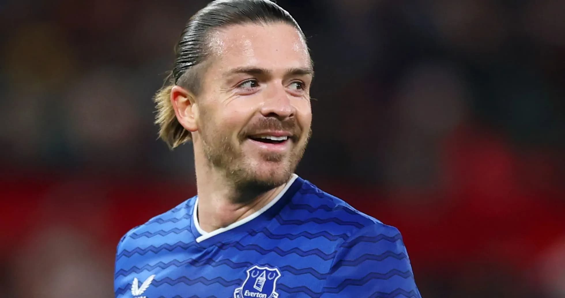 Игрок в синей форме Everton улыбается во время матча