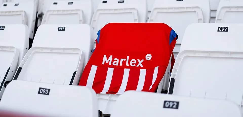 Красная футболка Marlex на пустых трибунах стадиона