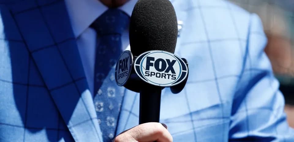 Рука держит микрофон FOX Sports с логотипом