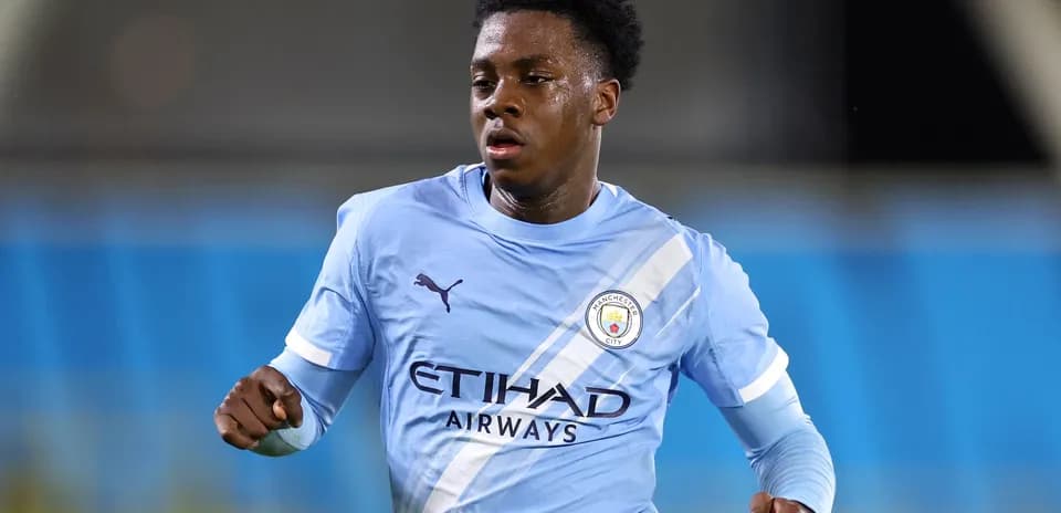 Игрок Manchester City бежит по полю в синей форме
