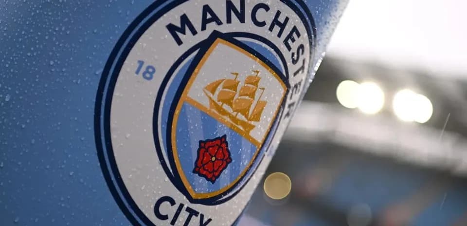 Логотип клуба Manchester City на фоне дождя