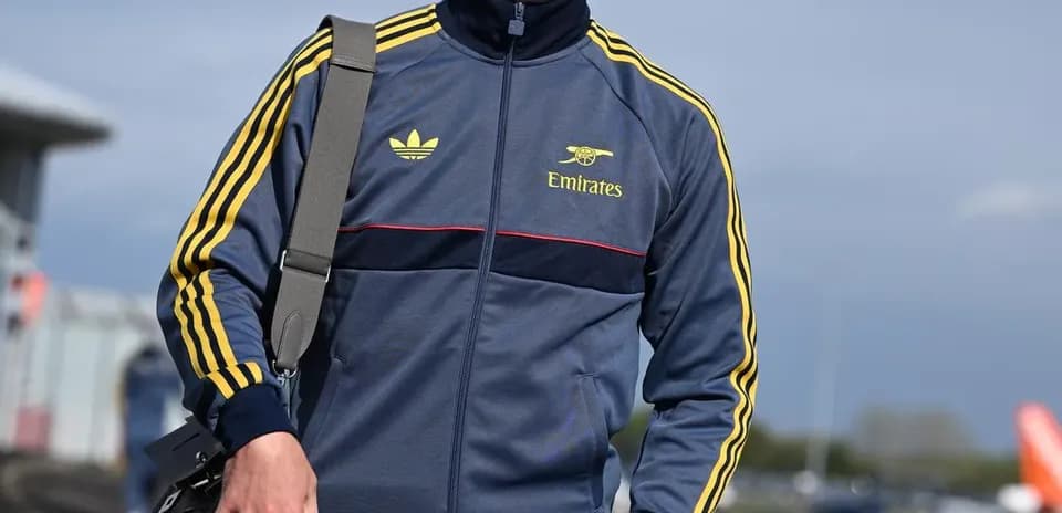 Игрок в спортивном костюме идет с сумкой