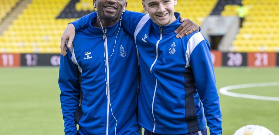 Два игрока позируют на футбольном поле