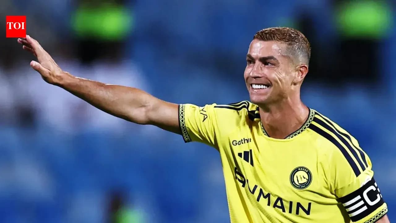 Игрок в желтой форме приветствует болельщиков на стадионе