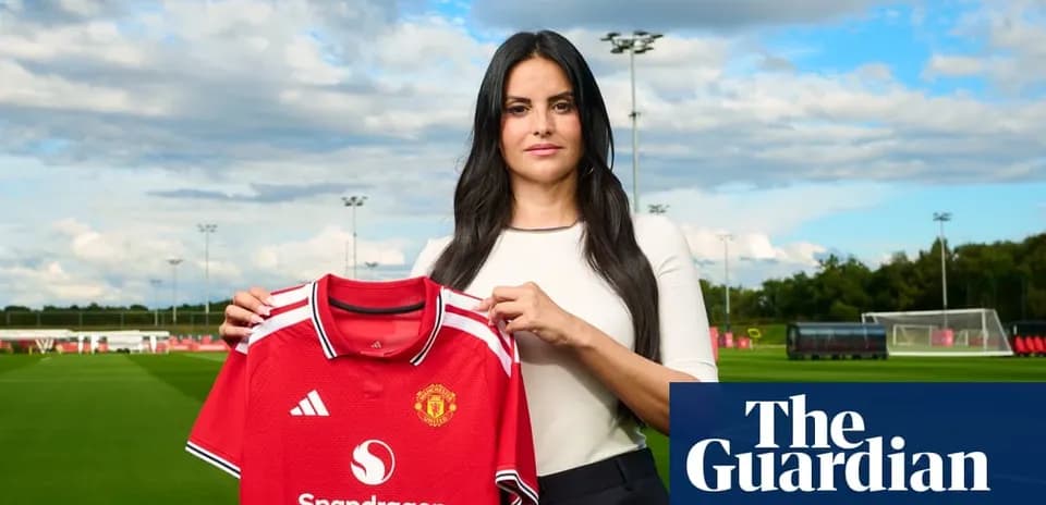 Женщина держит футболку Manchester United на поле