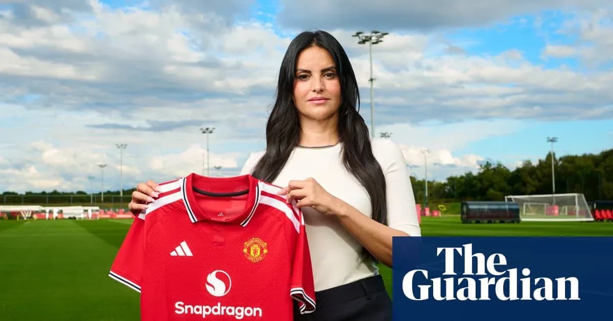 Женщина держит футболку Manchester United на поле
