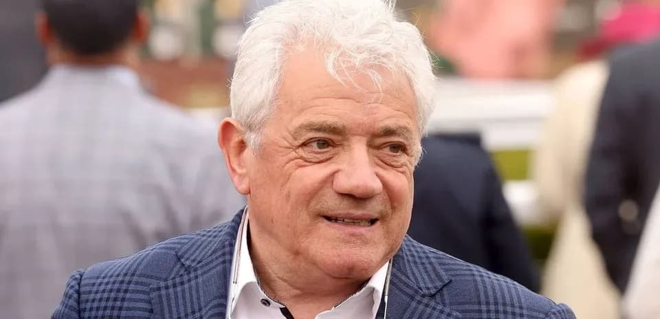 Человек в костюме на фоне зрителей на мероприятии