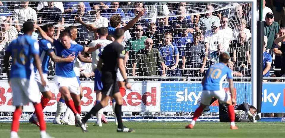 Players celebrating a goal in front of fans