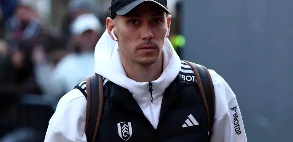 Игрок в спортивной одежде идет к стадиону