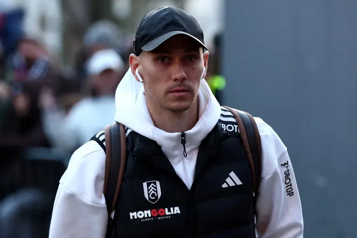 Игрок в спортивной одежде идет к стадиону