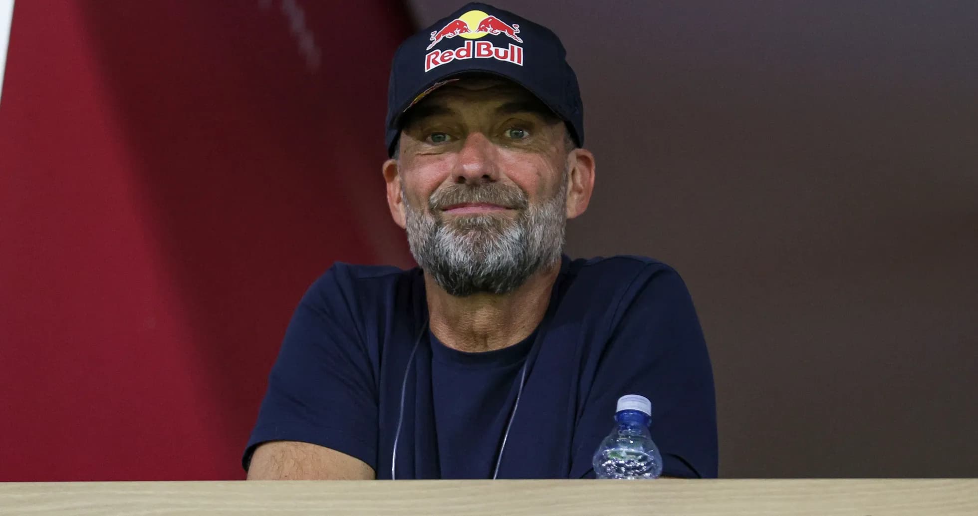 Человек в кепке Red Bull наблюдает за игрой