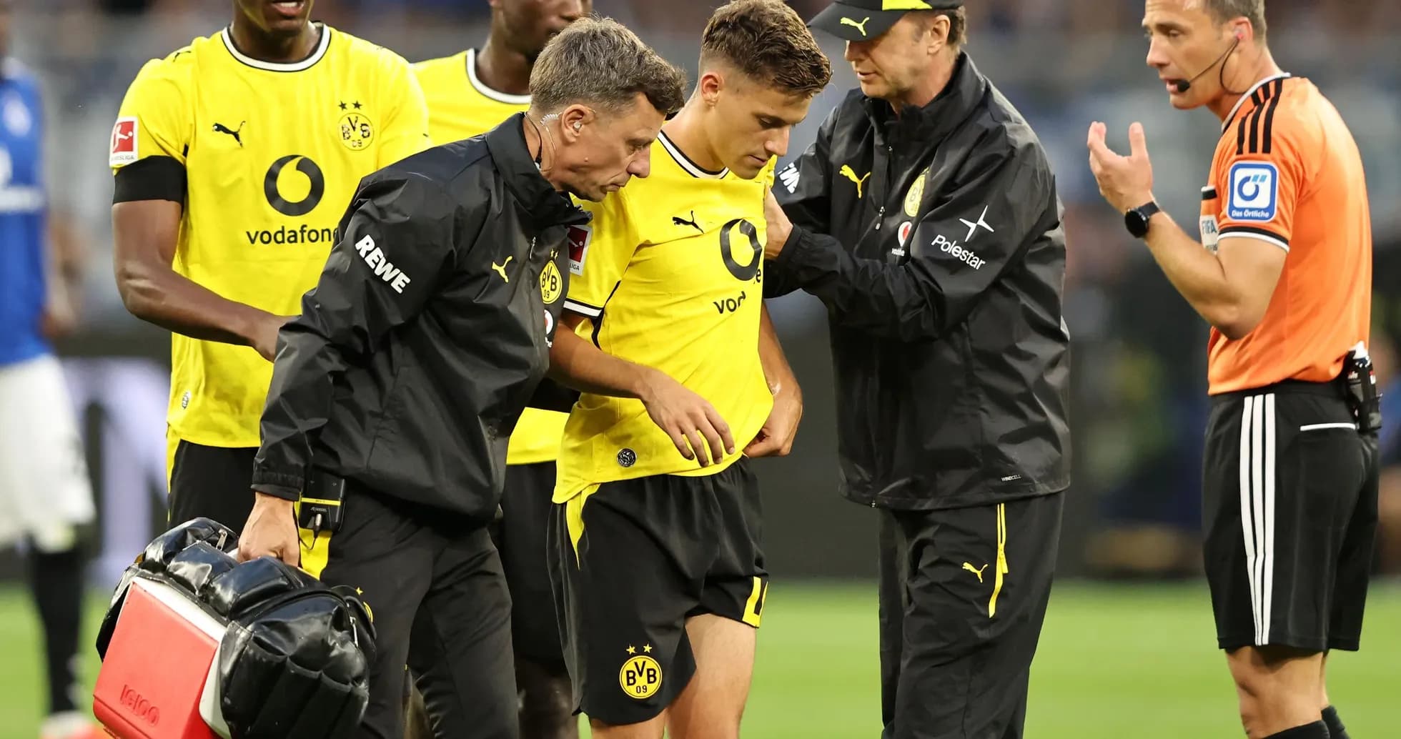 Игрок Borussia Dortmund получает медицинскую помощь на поле