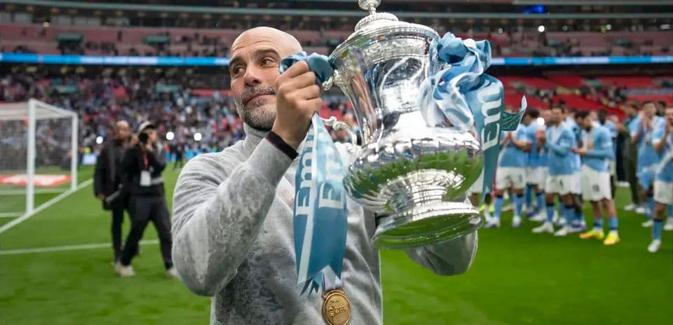 Тренер с трофеем на поле стадиона Wembley
