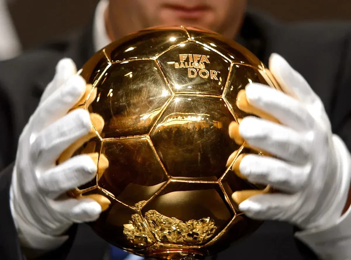 Человек держит Золотой мяч FIFA в руках