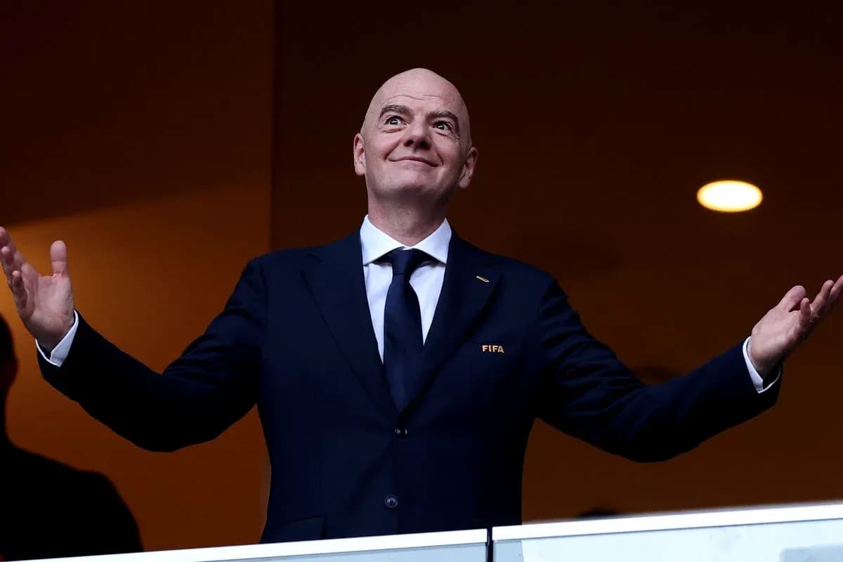 Председатель FIFA с поднятыми руками на трибуне