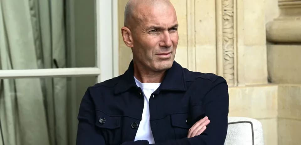 Человек с сложенными руками сидит на улице