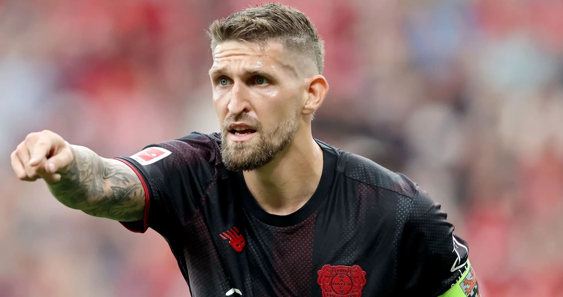 Игрок команды Bayer Leverkusen указывает на поле