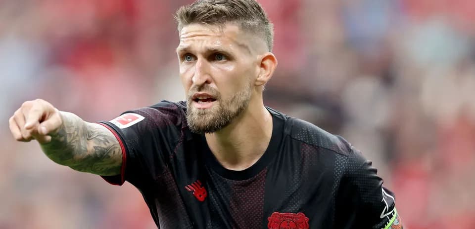Игрок команды Bayer Leverkusen указывает на поле