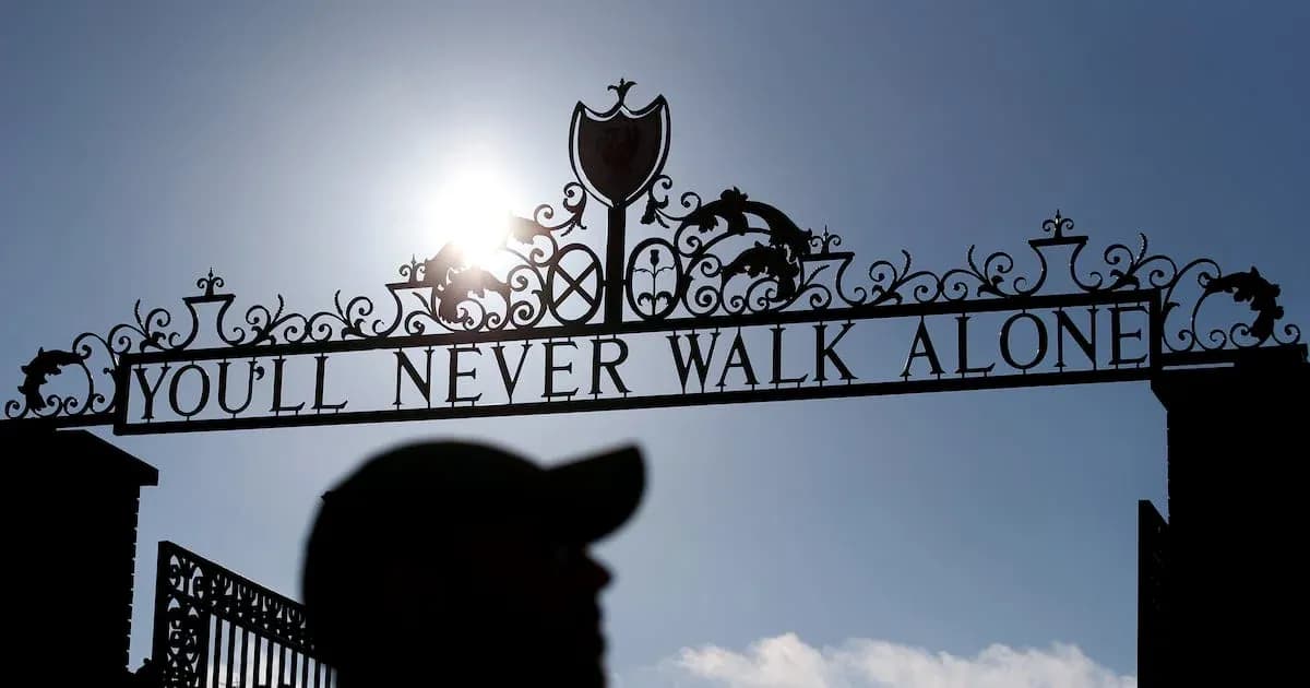 Знак 'YOU'LL NEVER WALK ALONE' на фоне солнца