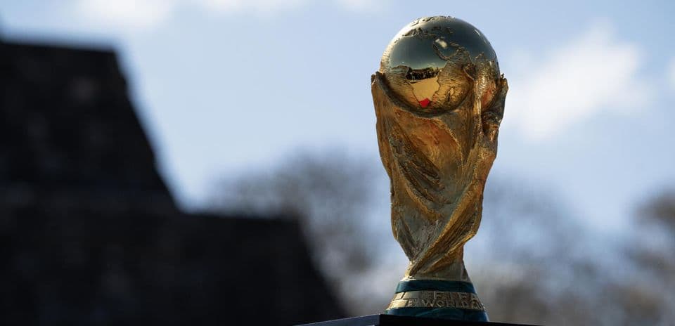 Золотой кубок FIFA на фоне неба