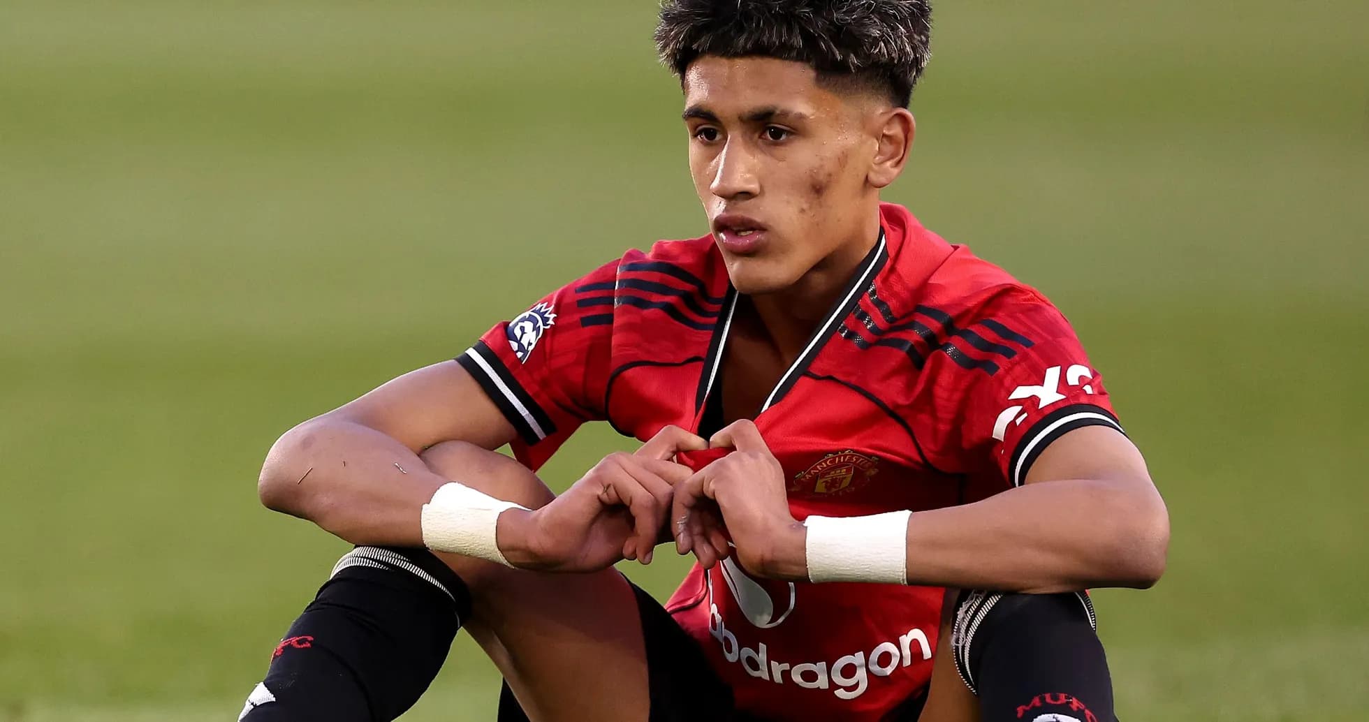 Игрок Manchester United сидит на поле после матча Игрок Manchester United сидит на поле после матча
