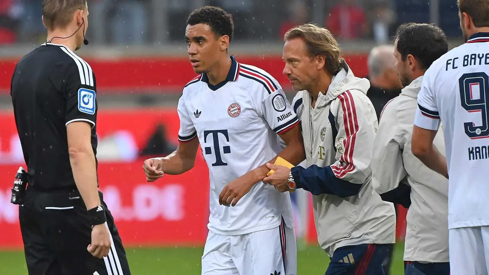 Игрок Bayern Munich получает медицинскую помощь на поле Игрок Bayern Munich получает медицинскую помощь на поле