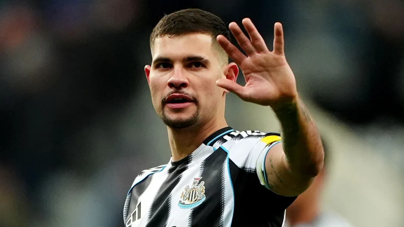 Игрок Newcastle United поднимает руку во время матча Игрок Newcastle United поднимает руку во время матча