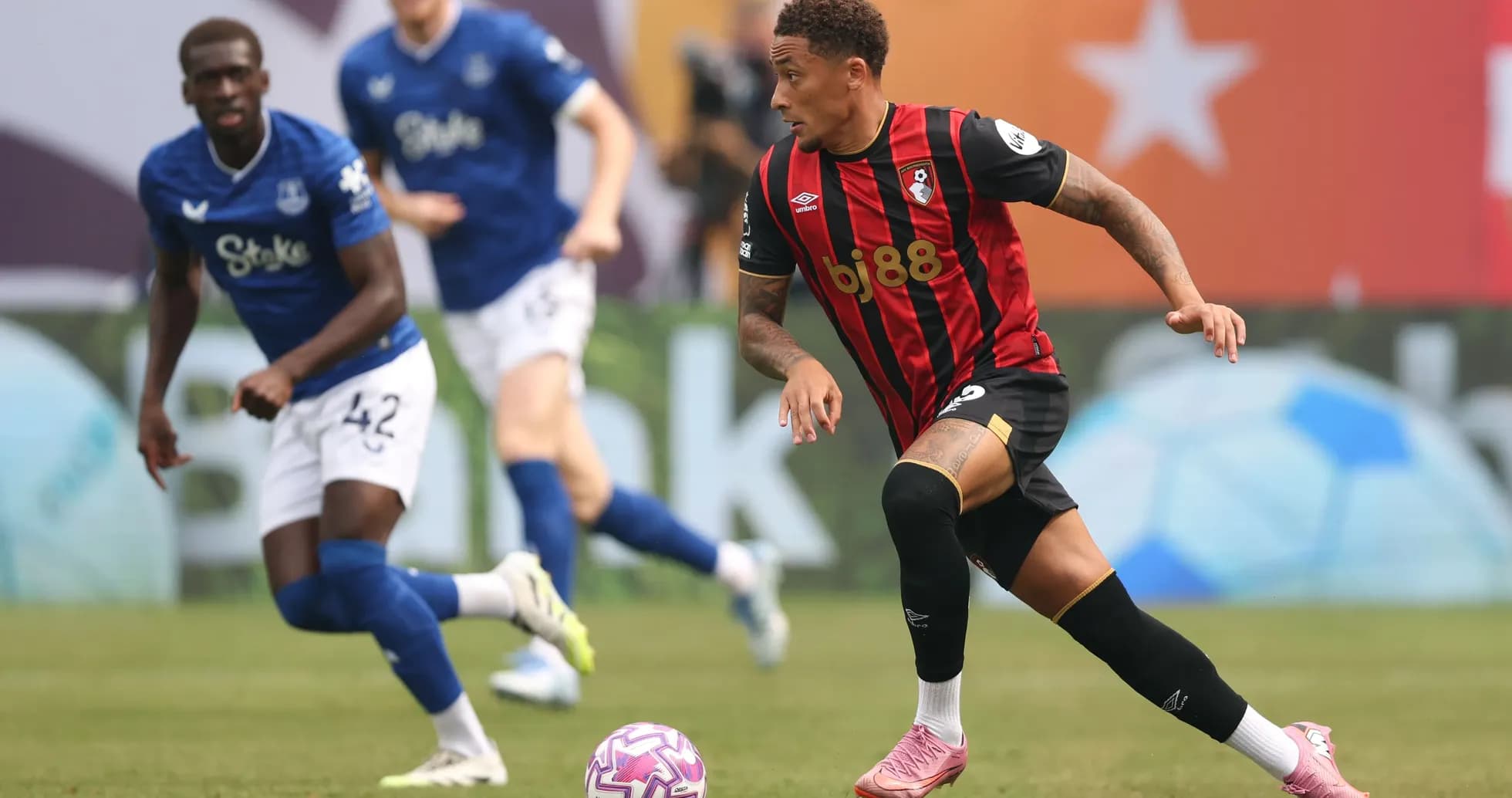 Игрок Bournemouth ведет мяч, игрок Everton в защите Игрок Bournemouth ведет мяч, игрок Everton в защите