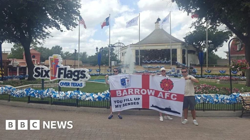 Два человека с флагом Barrow AFC у входа в Six Flags Два человека с флагом Barrow AFC у входа в Six Flags