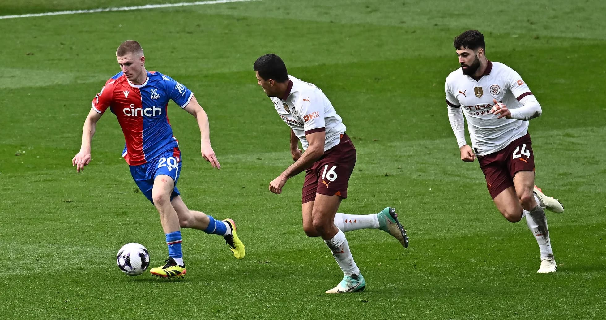 Игрок Crystal Palace ведет мяч, соперники преследуют Игрок Crystal Palace ведет мяч, соперники преследуют