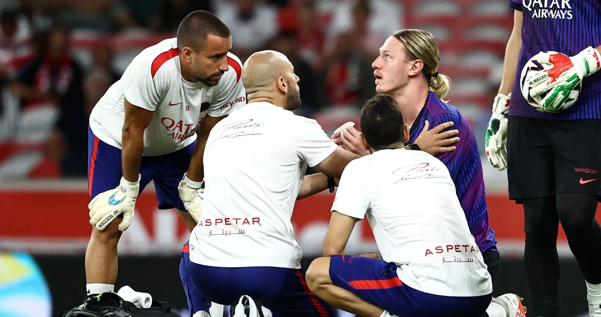 Врачи осматривают игрока на поле во время матча Врачи осматривают игрока на поле во время матча
